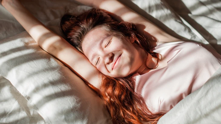 Mulher se esticando na cama