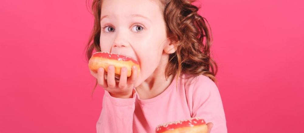 Criança comendo donut