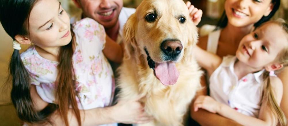 Família feliz ao redor de um cachorro