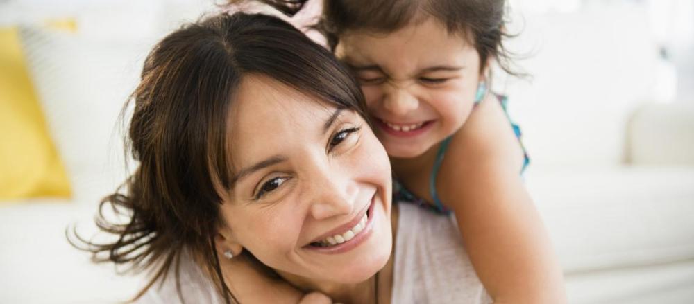 Mãe carregando crinança sorridente nas costas