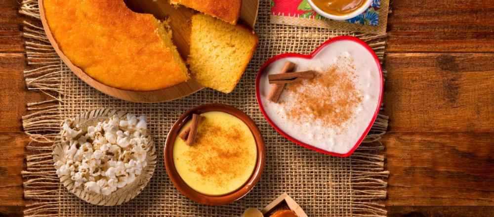 Mesa com comidas típicas de festa junina espalhadas