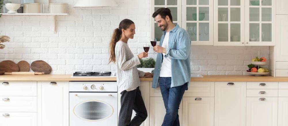 Casal tomando café em pés em uma cozinha