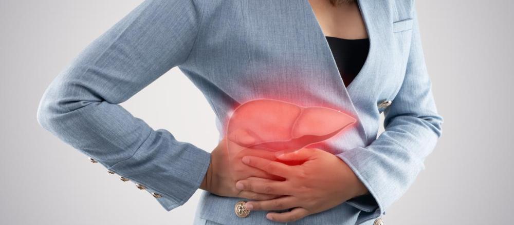 Mulher com as mãos sobre a região do fígado