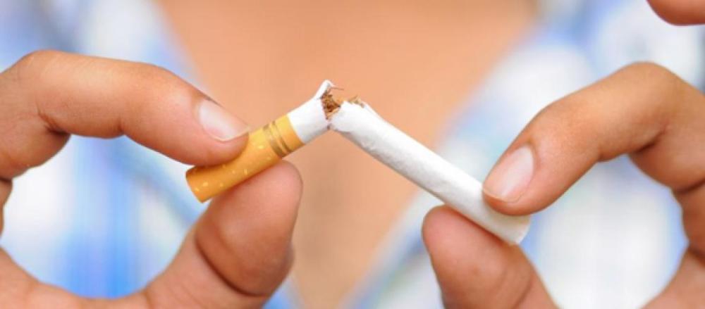 Pessoa quebrando cigarro ao meio