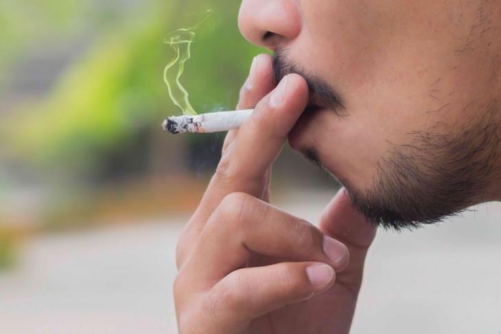 Imagem de um homem fumando cigarro, hábito que pode causar mau hálito, manchas nos dentes e aumentar o risco de doenças bucais