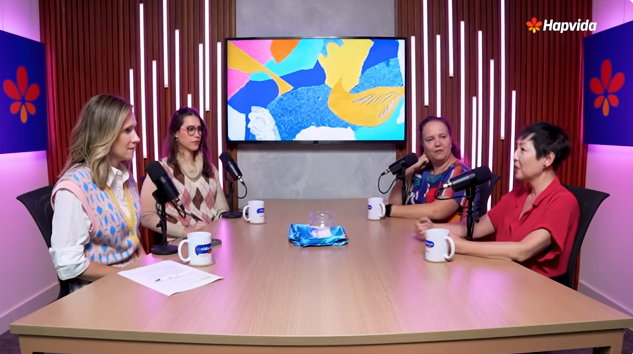 Quatro pessoas conversando na mesa do podcast