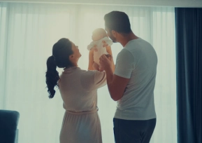 Mãe sorrindo com filha no colo, simbolizando acolhimento e compromisso da Política da Qualidade Hapvida com excelência no atendimento.