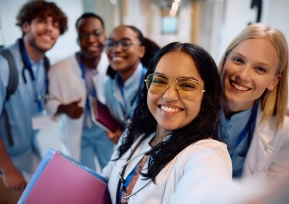 Grupo de estudantes de medicina sorrindo em um corredor hospitalar, simbolizando os programas de Residência Médica Hapvida.