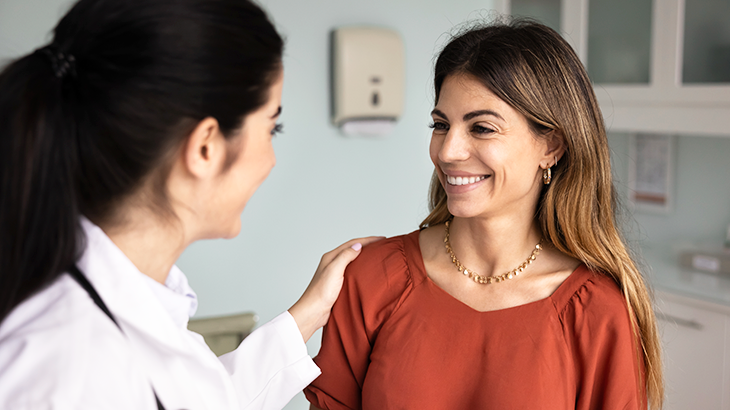 Profissional de saúde acolhe paciente durante consulta médica.