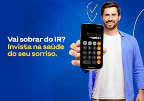 Homem com celular na mão sorrindo.