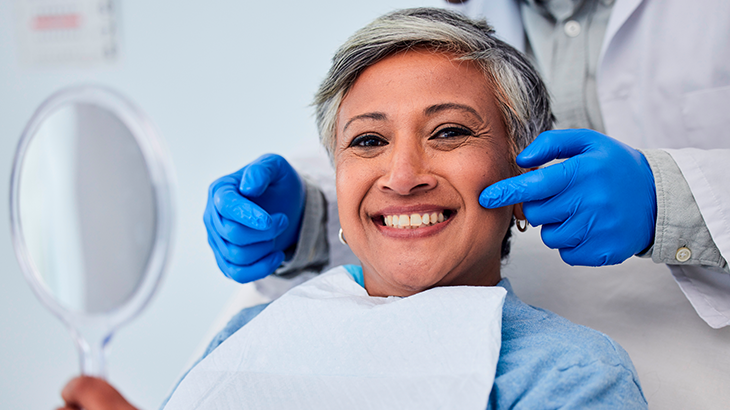 Imagem de uma mulher sorrindo em um consultório de dentista