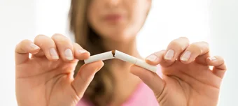 Mulher quebrando cigarro ao meio.