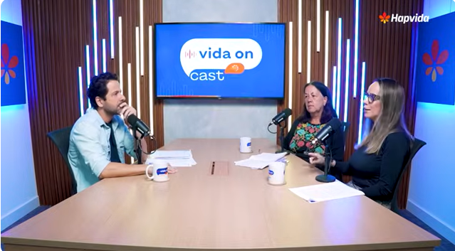 Três pessoas conversando na mesa do podcast